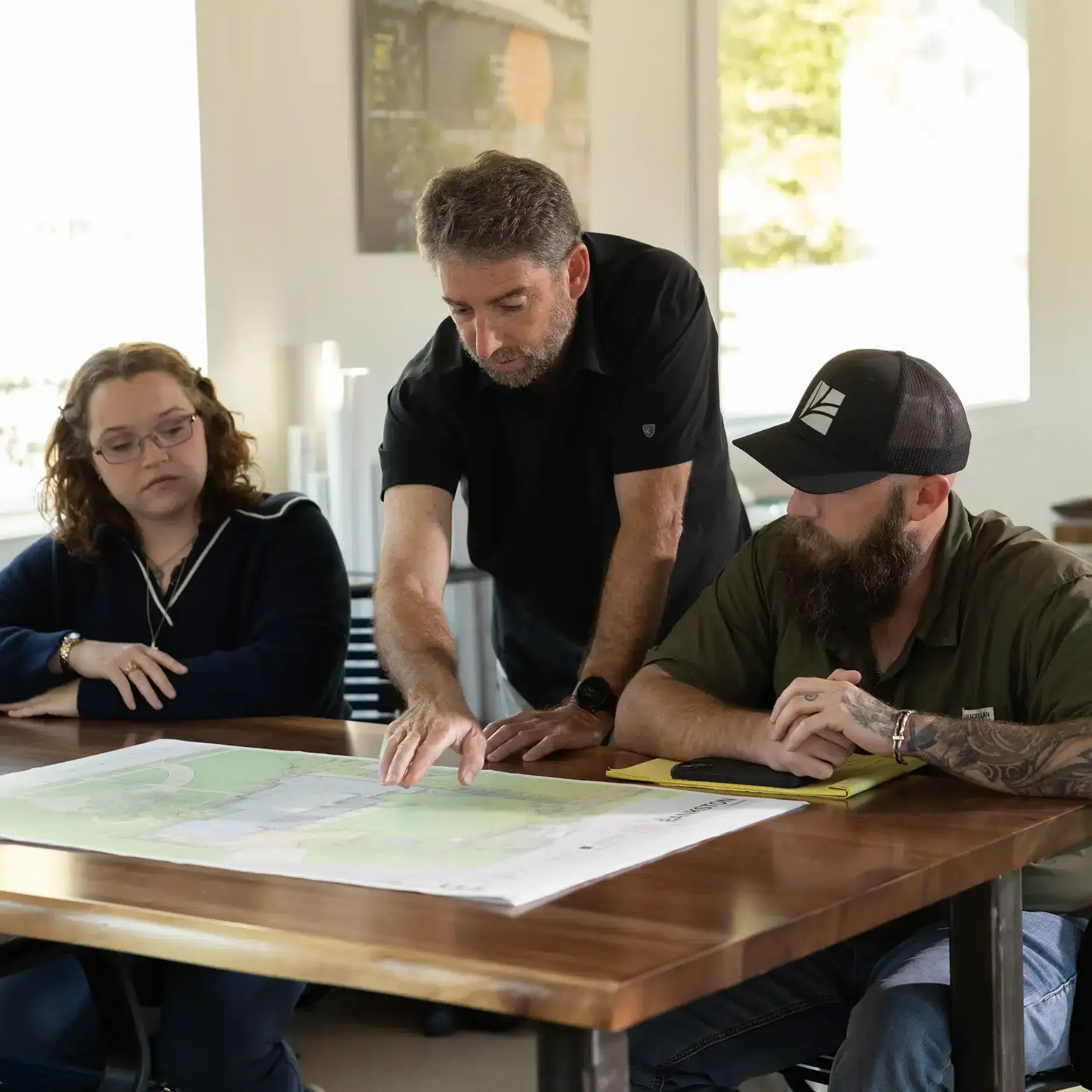 Landvisions landscape design team reviewing large format site plan drawing at Tyler Texas design studio